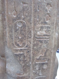 Close up of hyroglyphic writing on stone statue before steam cleaning